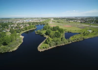 Aerial photo over water of sports fields, residential and Highway II in Leduc