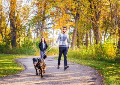 Couple walking a dog inEvergreen Park Pathway, Brooks