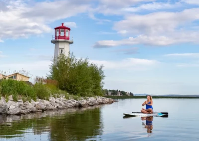 Woman doing paddle board yoga near the lighthouse in Sylvan Lake